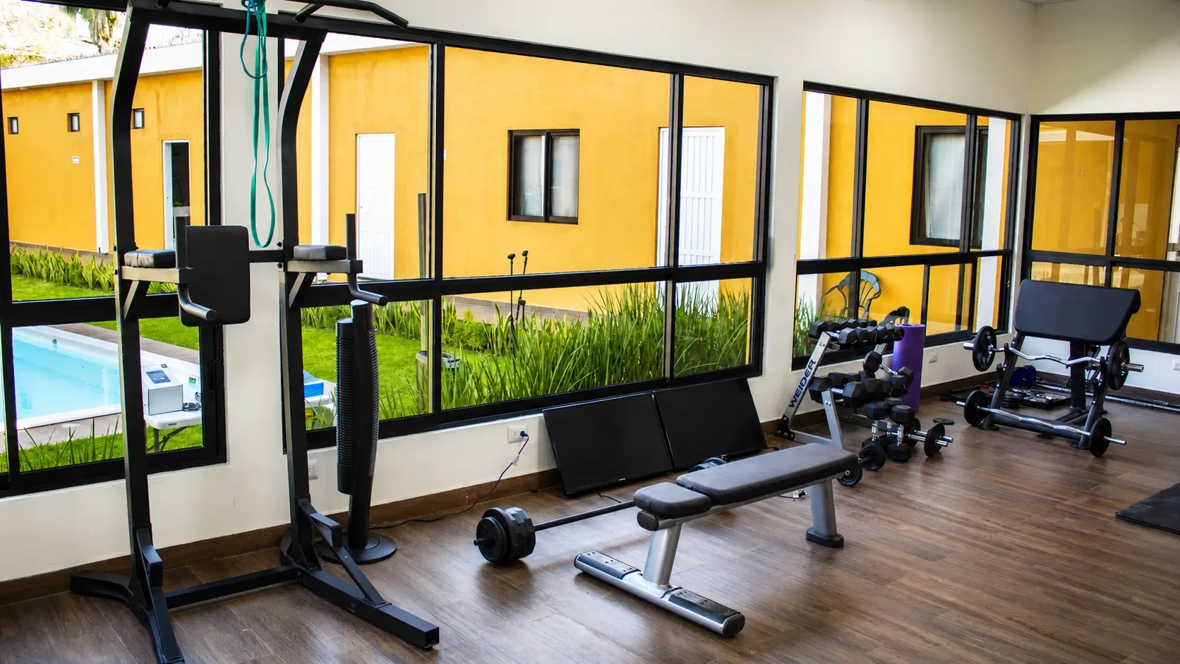 Gym with exercise equipment and large windows facing the garden