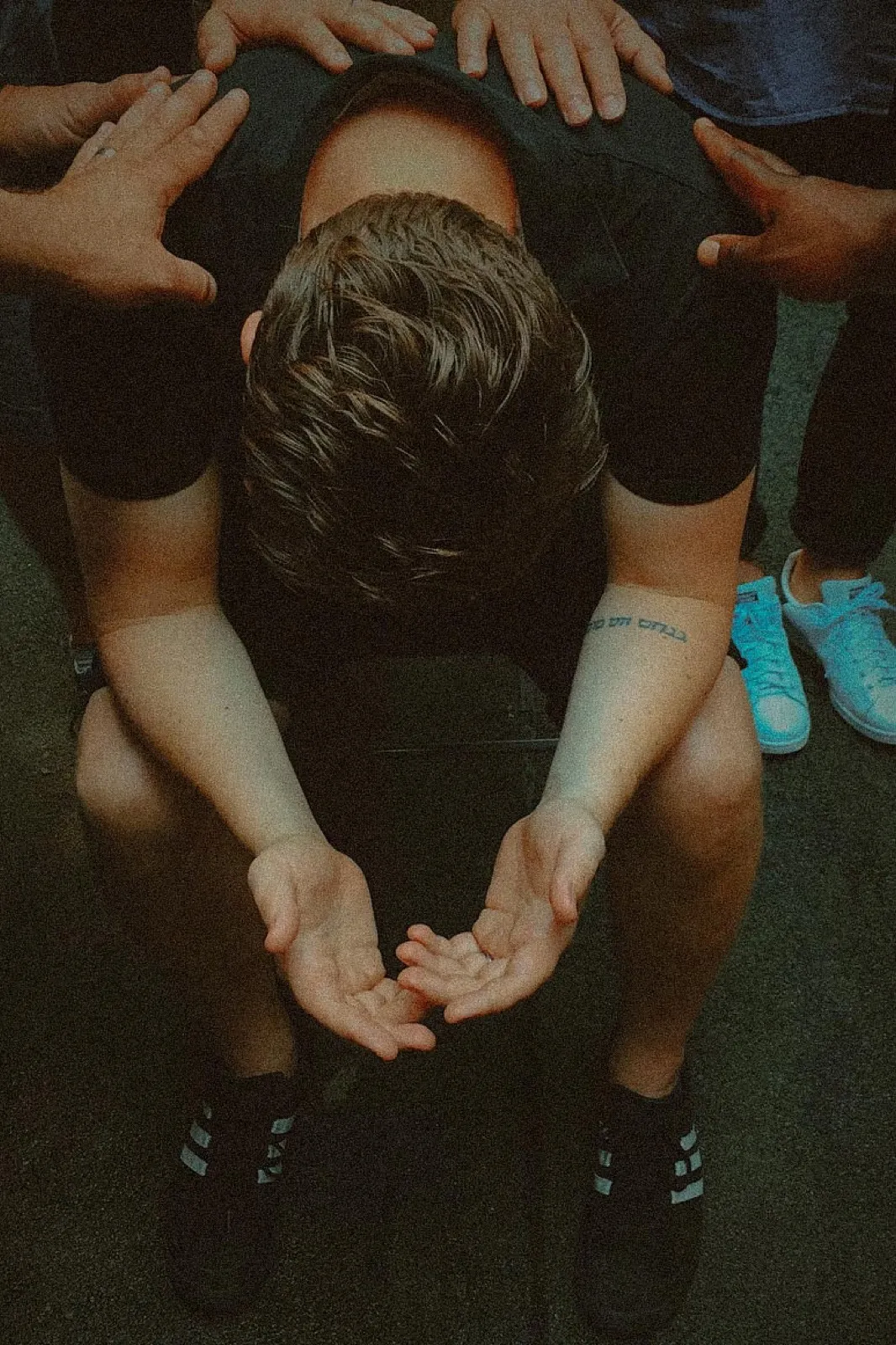 A group of people placing their hands on a peer