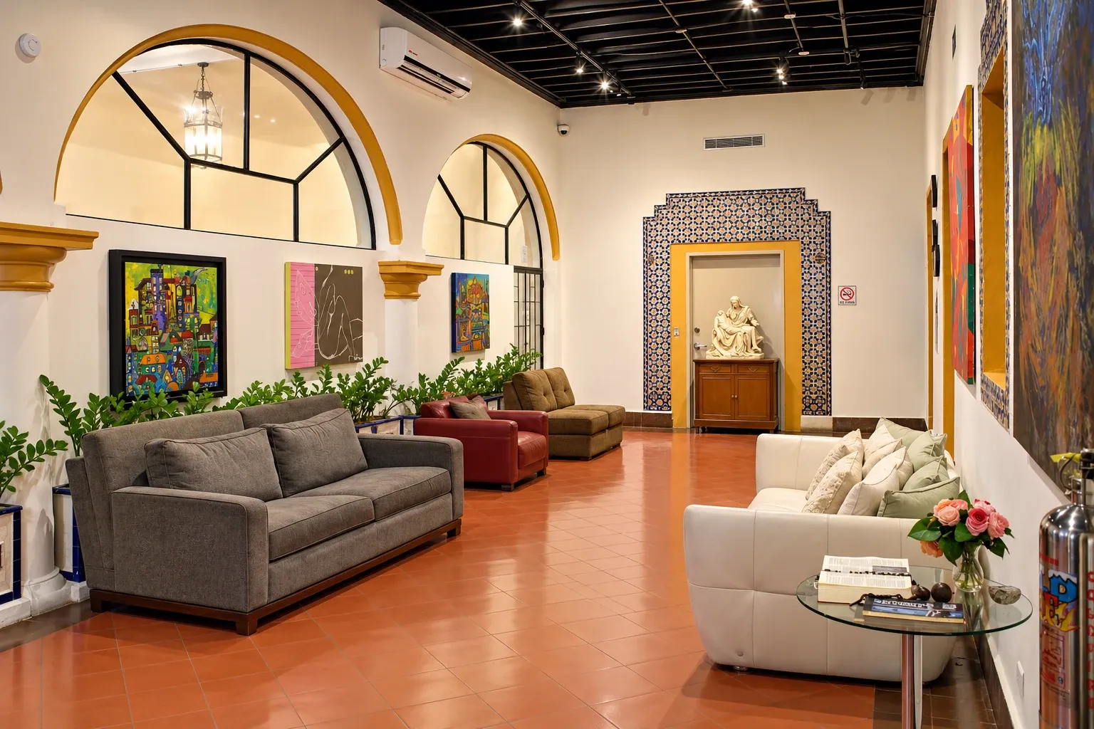 Main hallway with armchairs, arches and artwork