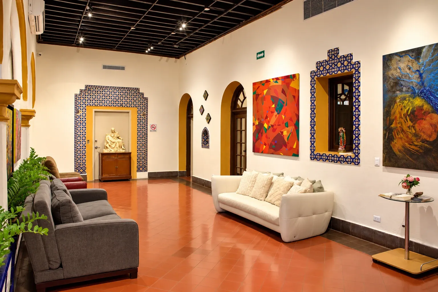 Main hallway with a white sofa, tilework and paintings